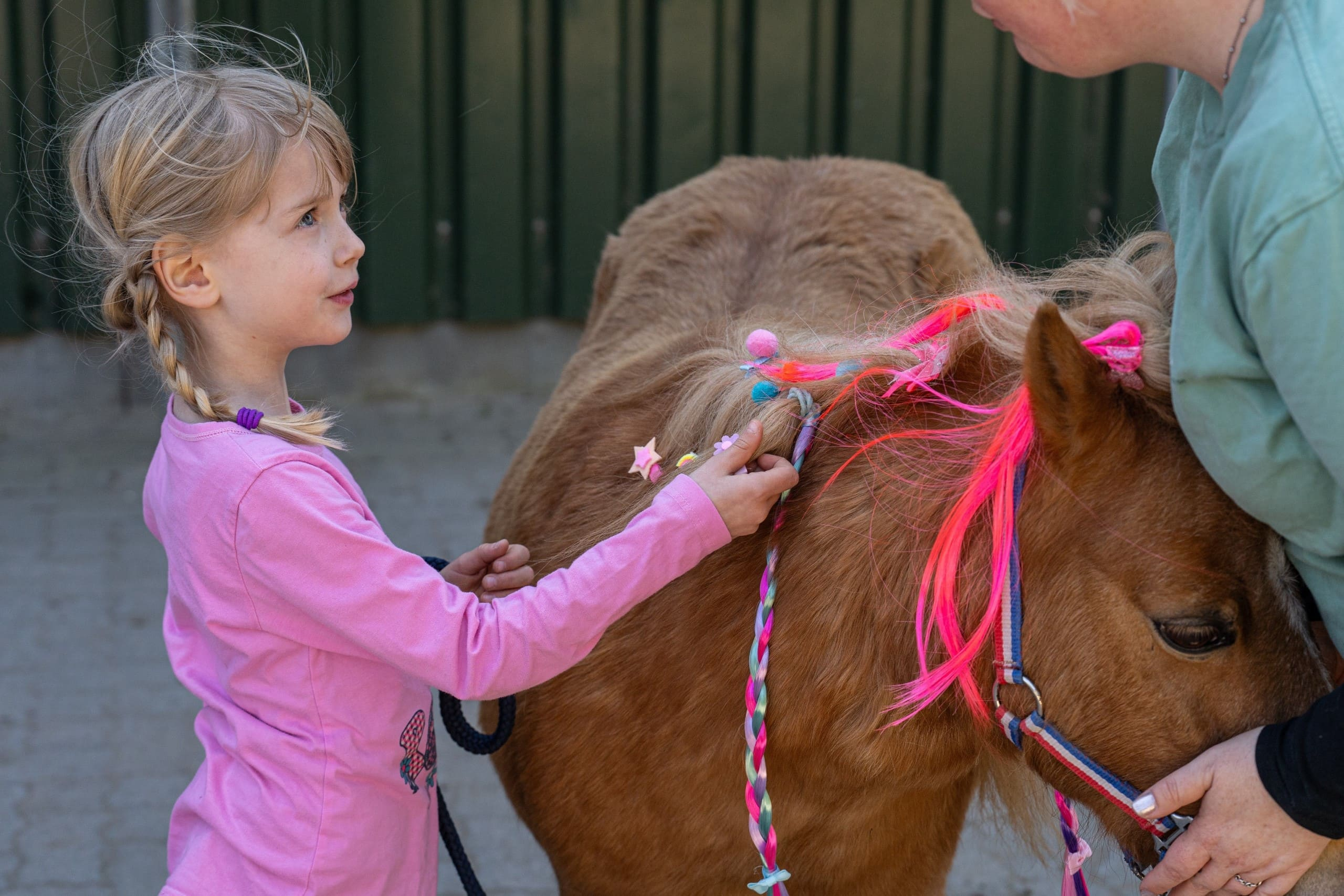 Kind schmückt Pony