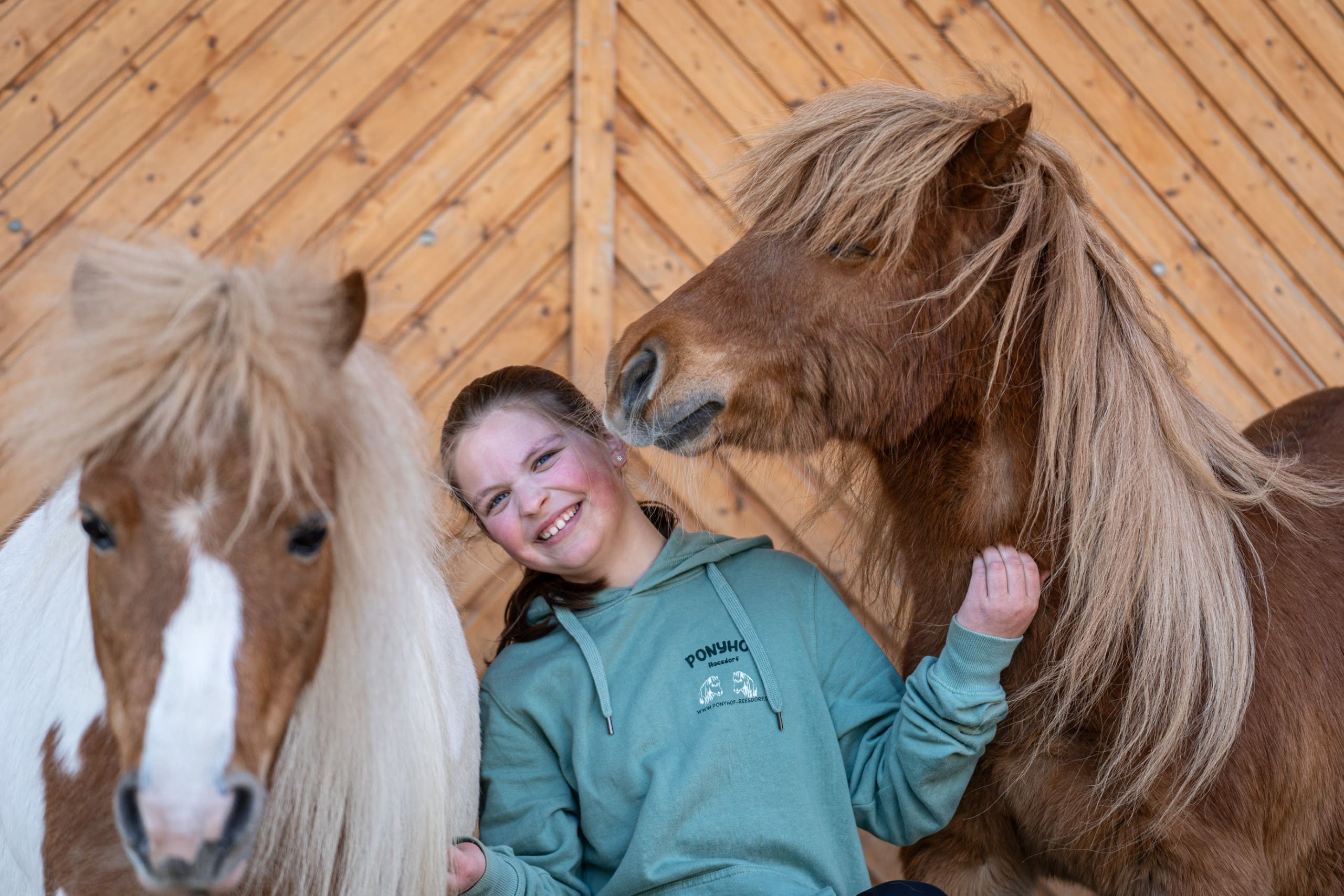 Kind zwischen 2 Ponys